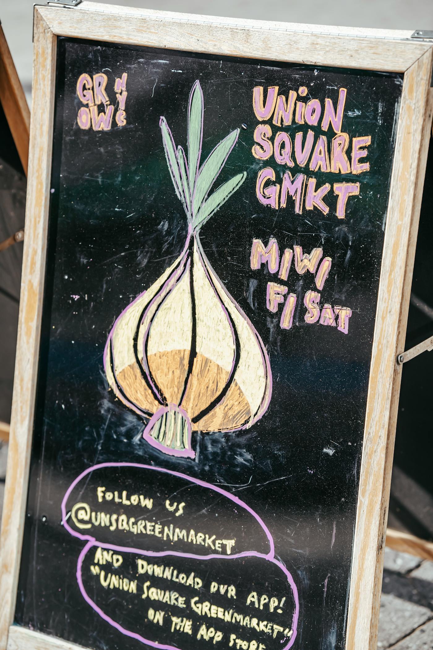 Local market chalkboard sign on a city street.